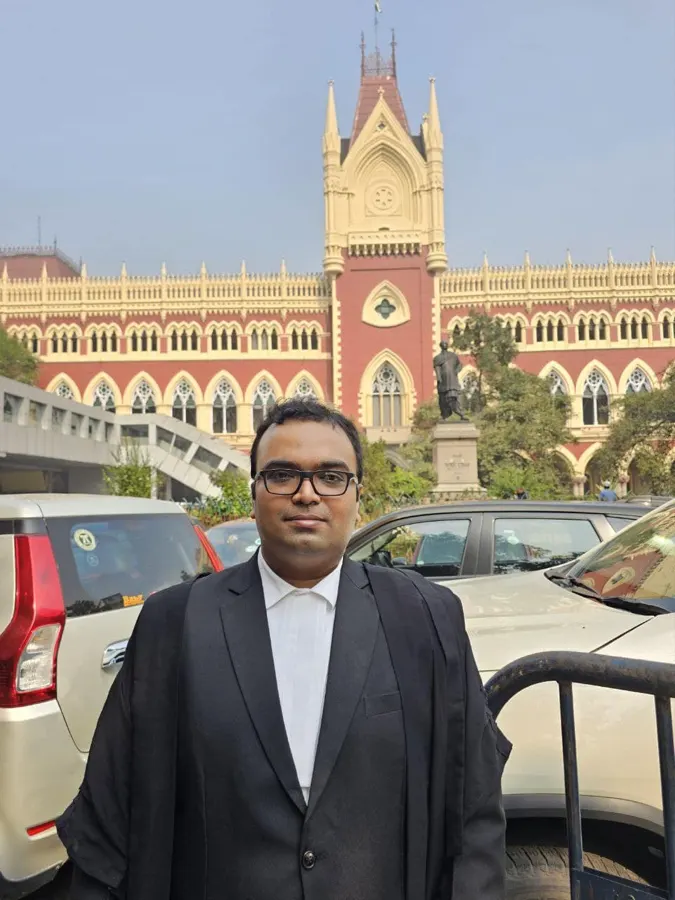 Advocate Sudip Patra standing in front of the Calcutta High Court's red Gothic building